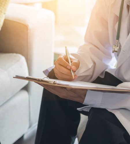 Doctor consulting male patient, working on diagnostic examination on men's health disease or mental illness, while writing on prescription record information document in clinic or hospital office